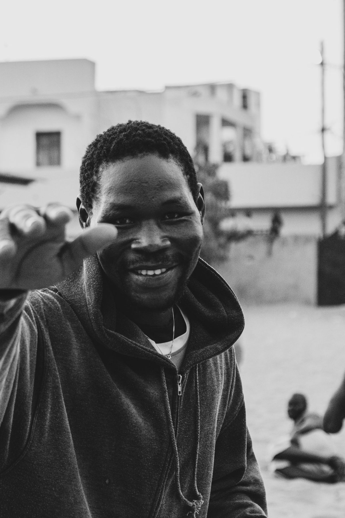 A smiling man reaching his hand toward the camera