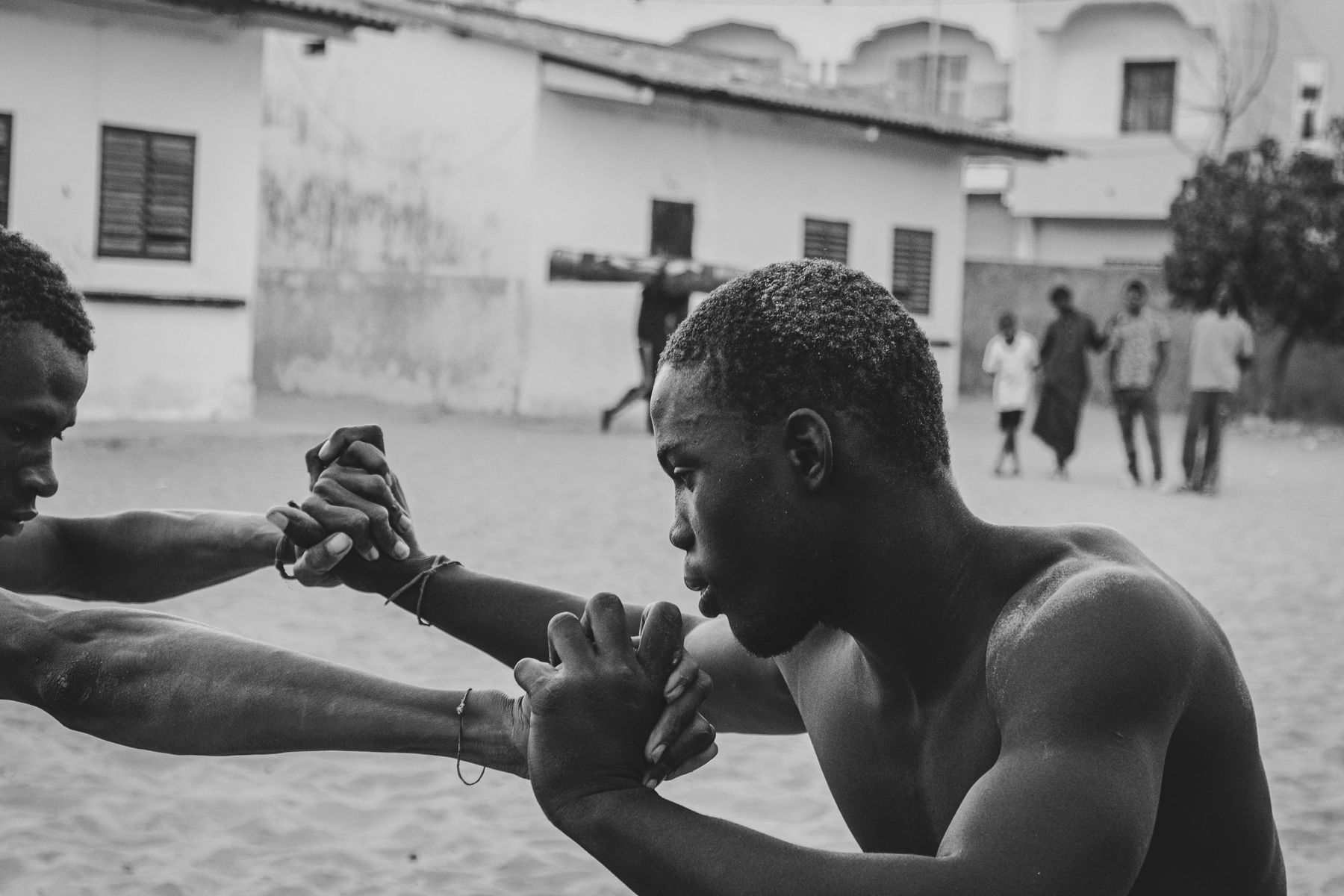 Two wrestlers gripping hands, intense focus